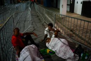 Football fans sleep outside the Vila Belmiro stadium and wait for the doors to open Monday morning for Pele's wake. [Matias Delacroix/AP Photo]