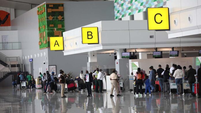 [files] Passengers wait in line at the departure terminal of the Nnamdi Azikiwe International Airport, in Abuja, Nigeria on September 7, 2020. (Photo by Kola Sulaimon / AFP)