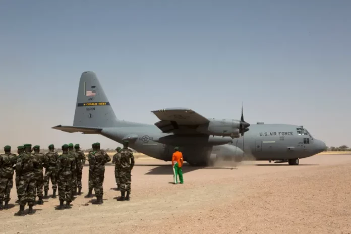 A C-130 US Air Force plane lands as Nigerien soldiers stand in formation during military exercise with US Special Forces in Diffa region in 2014 [File: Joe Penney/Reuters]