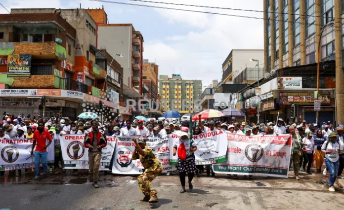 Members of Operation Dudula, using a slogan ‘Put South Africa First’, take part in a rally to force undocumented foreigners from informal trading in Hillbrow, an inner-city suburb with a large population of African migrants in Johannesburg, South Africa, on February 19, 2022 [Siphiwe Sibeko/Reuters]