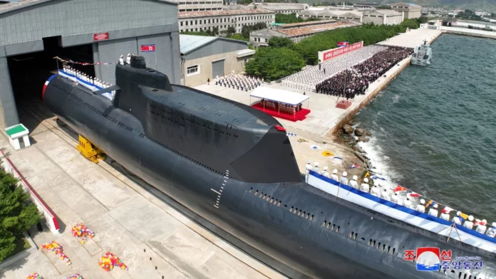 People attend what North Korean state media said was a launch ceremony for a new tactical nuclear attack submarine, in a handout image released on September 8, 2023. KCNA/Reuters