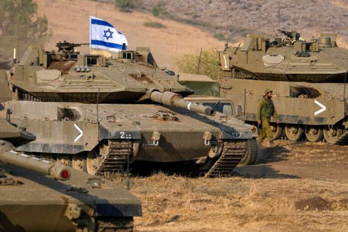 Israeli tanks are stationed near the border with Lebanon on Wednesday. Ariel Schalit / AP