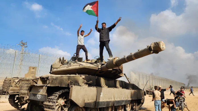 Palestinians wave their national flag on top of an Israeli tank east of the Khan Yunis border crossing. Photograph: Yousef Masoud/AP