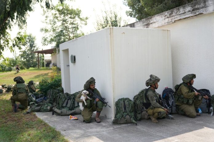 Israeli soldiers in the village of Kfar Aza near the border with Gaza (AP)