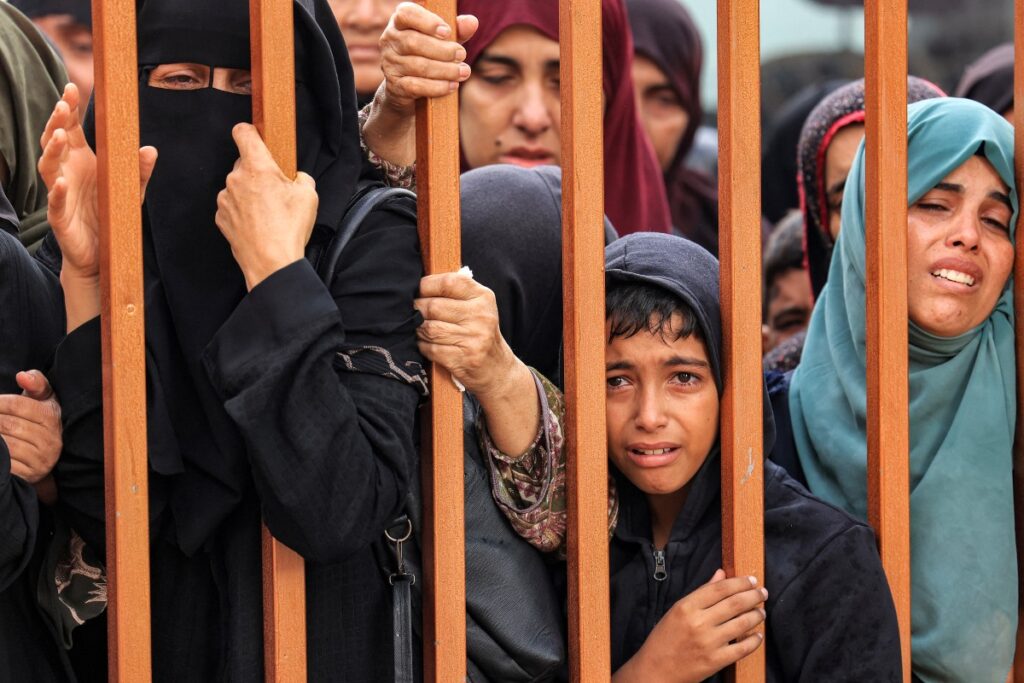 FILE: People mourn as they stand behind a metal fence near the bodies of victims who were killed in Israeli bombardment before their burial, outside the morgue at Nasser Hospital in Khan Yunis in the southern Gaza Strip on November 14, 2023, amid the ongoing battles between Israel and the Palestinian militant group Hamas. (Photo by MAHMUD HAMS / AFP)