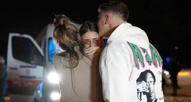 A handout picture provided by Israel’s Government Press Office (GPO), shows former Franco-Israeli hostage Mia Shem (C) with her mother and brother upon arrival at the Hatzerim air base following her release by the Palestinian Hamas group on November 30, 2023. (Photo by GPO / AFP)