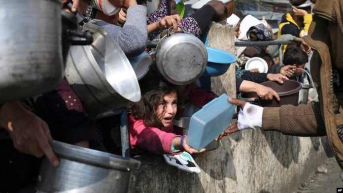 FILE - Palestinians line up for free food during the ongoing Israeli air and ground offensive on the Gaza Strip in Rafah, Jan. 9, 2024.