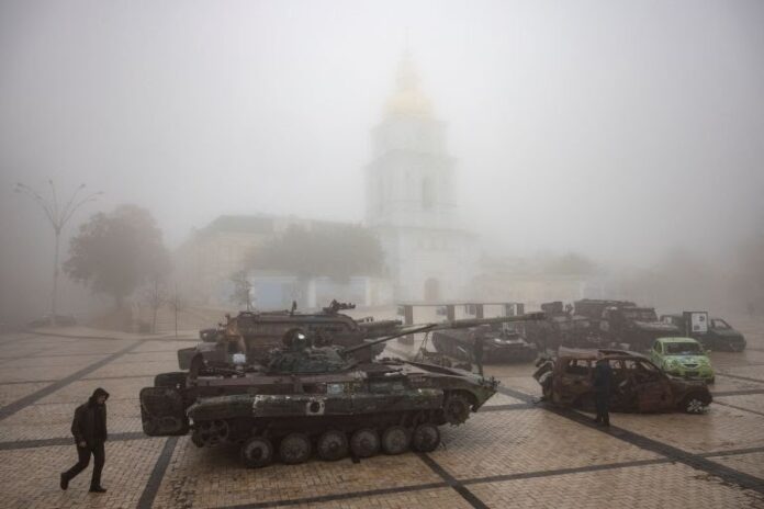 A man walks past destroyed Russian military vehicles outside St Michael's Golden-Domed Monastery on a foggy morning in Kyiv, Ukraine, October 21, 2023 [Thomas Peter/Reuters