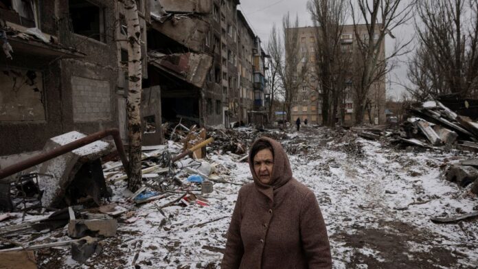 A woman walks past apartment blocks that were destroyed in a Russian missile strike, amid Russia’s attack on Ukraine, in Selydove near Avdiivka, Ukraine, on February 19, 2024. (Reuters)