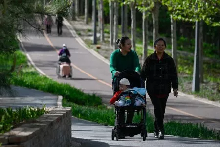 People walk in a public park in Beijing on April 15, 2023. A Shanghai Academy of Social Sciences research team has predicted China's population will fall to 525 million by 2100.WANG ZHAO/AFP VIA GETTY IMAGES