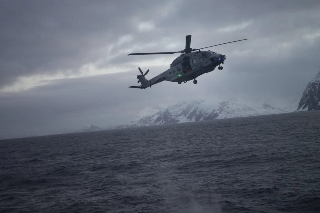 A helicopter approaches to land on the French navy frigate Normandie during a patrol in a Norwegian fjord, north of the Arctic circle, on March 7, 2024. (AP Photo/Thibault Camus)