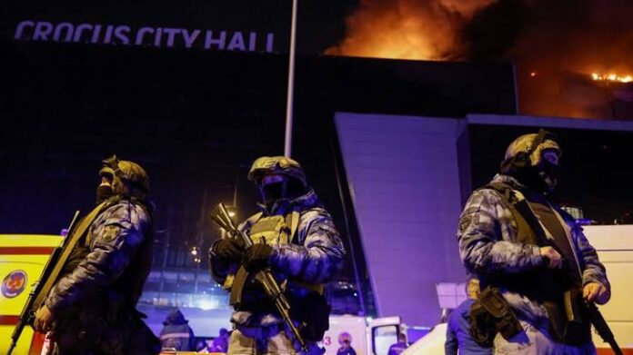 Image:Russian authorities stand guard near the burning Crocus City Hall concert venue. Pic: Reuters
