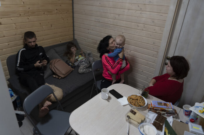 50-year-old Natalia Zhyvohliad, an internally displaced person from Nova Petrivka in the Zaporizhzhia region of Ukraine, with her children, daughter-in-law and grandson in their temporary modular house in Kolomyya, Ivano-Frankivsk region on Feb. 13, 2024. (AP)