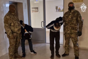This video grab taken from a handout footage released by Russia's Investigative Committee on March 24, 2024, shows law enforcement officers escorting two of the concert hall attack suspects to court. (AFP)