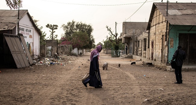 A man walks down a road in Ndiaganiao on March 27, 2024. – The small Senegalese town of Ndiaganiao emerged from anonymity after the accession to power of one of its children, Bassirou Diomaye Faye, who is the pride of its inhabitants. (Photo by JOHN WESSELS / AFP)