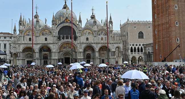 People attend a holy mass presided by Pope Francis at St. Marks square on April 28, 2024 in Venice. – Pope Francis visits Venice today, his first trip outside Rome in seven months, which will be closely watched amid concerns over the 87-year-old’s fragile health. (Photo by ANDREA PATTARO / AFP)