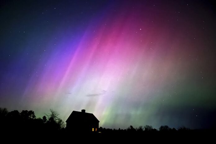 The northern lights flare in the sky over a farmhouse, late Friday, May 10, 2024, in Brunswick, Maine. AP/Robert F. Bukaty