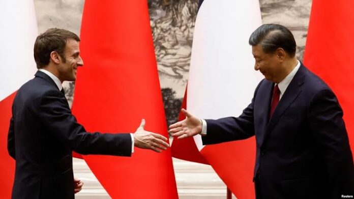 French President Emmanuel Macron (left) and Chinese President Xi Jinping shake hands at the Great Hall of the People in Beijing on April 6.