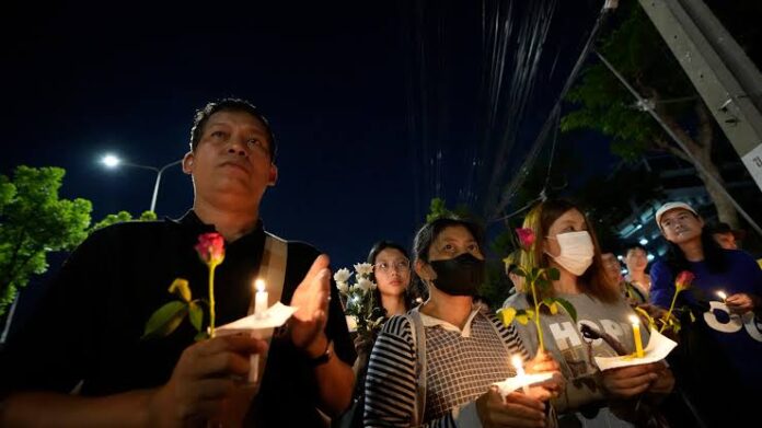 Thai activists hold candles during a vigil for Netiporn Sanesangkhom, a member of the activist group Thaluwang, known for their bold and aggressive campaigns demanding reform of the monarchy and abolition of the law that makes it illegal to defame members of the royal family, outside of Criminal court in Bangkok, Thailand, Tuesday, May 14, 2024. Netiporn who went on a hunger strike after being jailed for her involvement in protests calling for reform of the country's monarchy system died Tuesday in a prison hospital, officials said. (AP Photo/Sakchai Lalit)