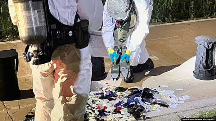 This handout photo released on June 2, 2024 shows South Korean military officers check unidentified objects believed to be North Korean trash from balloons that crossed the inter-Korea border, on a street in Seoul.