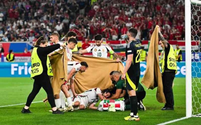 Hungry players and stewards hold a cloth as Vargas Barnabas is being treated after a dangerous injury. [AFP]
