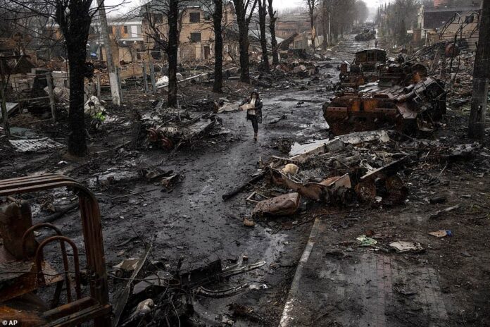A Ukrainian civilian walks along a street littered with the remains of Russian tanks and armoured vehicles after the city of Bucha, on the western outskirts of Kyiv, was recaptured by Ukrainian forces. AP