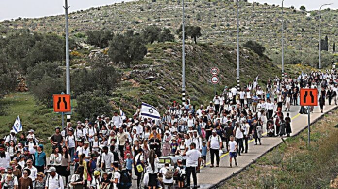 Israeli settlers march toward the outpost of Eviatar, near the Palestinian village of Beita, south of Nablus in the West Bank. (File photo: AFP)