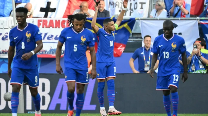 Kylian Mbappe removed his mask to celebrate scoring a penalty to put France ahead but they were frustrated by Poland © Alberto PIZZOLI / AFP