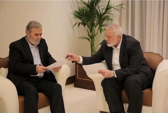 Hamas leader Ismail Haniyeh and Islamic Jihad leader Ziyad Al Nakhalaj discuss the ceasefire proposal before they response to Qatari and Egyptian mediators in Doha, Qatar, June 11, 2024. Hamas Media Office/Handout via REUTERS 