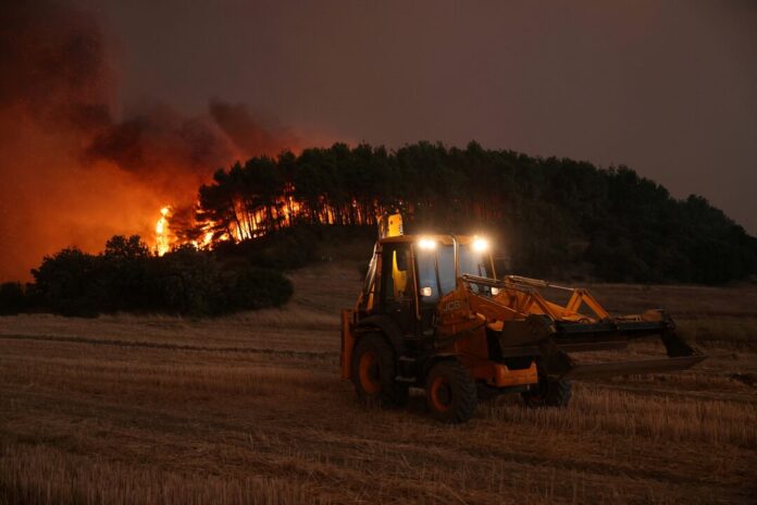 A bulldozer operates as a wildfire burns near the village of Avantas in the region of Evros, Greece, August 21. REUTERS/Alexandros Avramidis