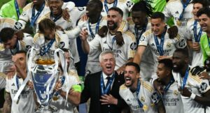 Real Madrid’s Italian coach Carlo Ancelotti and his players celebrate with the trophy after the UEFA Champions League final football match between Borussia Dortmund and Real Madrid, at Wembley stadium, in London, on June 1, 2024. (Photo by Ben Stansall / AFP)