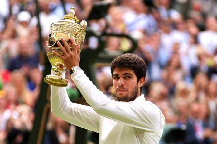 Carlos Alcaraz lifts trophy after having defeated Novak Djokovic at Wimbledon in London on Sunday.Clive Brunskill / Getty Images
