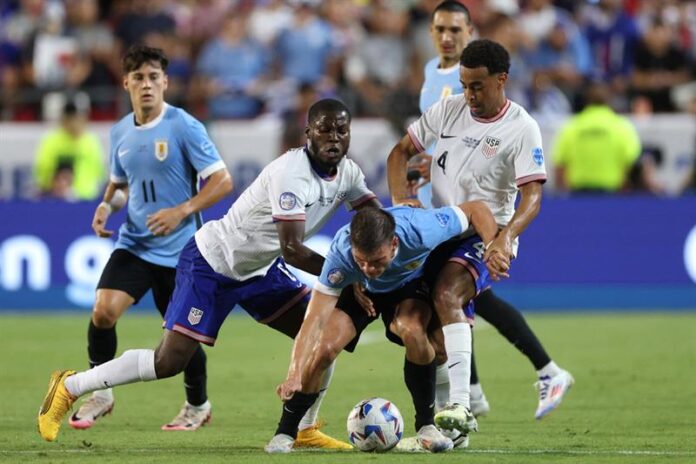 Yunus Musah and Tyler Adams of United States battles for possession with Manuel Ugarte of Uruguay during the CONMEBOL Copa America 2024 Group C match between United States and Uruguay at GEHA Field at Arrowhead Stadium on July 01, 2024 in Kansas City, Missouri. Photo: AFP