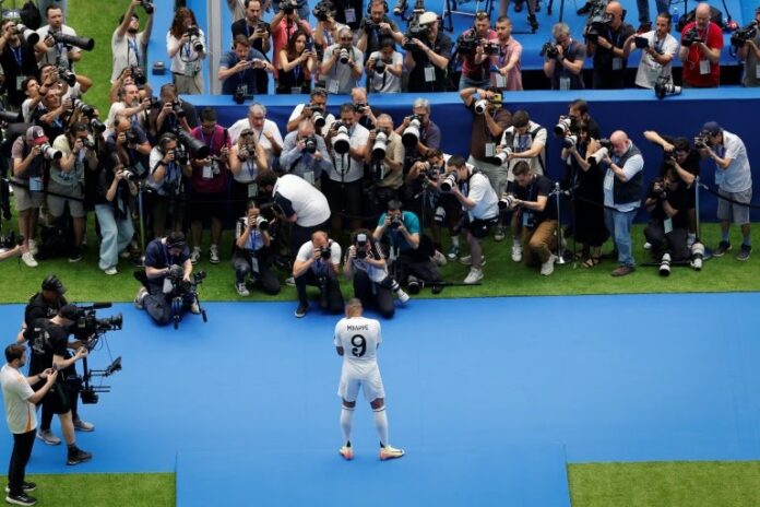Kylian Mbappe poses for photos during his first appearance as a Real Madrid player at Santiago Bernabeu stadium OSCAR DEL POZO