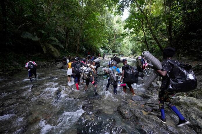 Migrants, mostly Haitians, cross the Acandi River on their journey north, from Colombia into Panama in hopes of reaching the U.S, near Acandi, Colombia, Sept. 15, 2021. Doctors Without Borders warned on May 18, 2022 of a deterioration in the medical care of the hundreds of migrants arriving daily at reception centers in remote communities after crossing the dangerous jungle of Darién, on the border zone of Panama with Colombia. (AP Photo/Fernando Vergara, File)