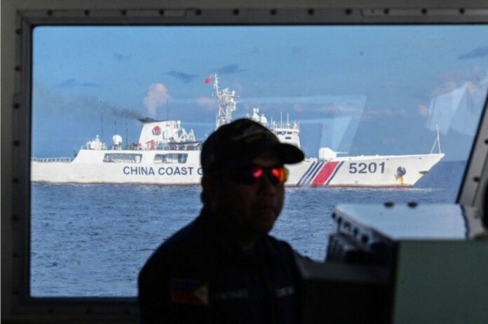 A member of the Philippine Coast Guard while is shown as his ship is being shadowed by a China Coast Guard ship at Second Thomas Shoal in the Spratly Islands in the disputed South China Sea. Photo: Asia Times Files / Facebook Screengrab / Philippine Star