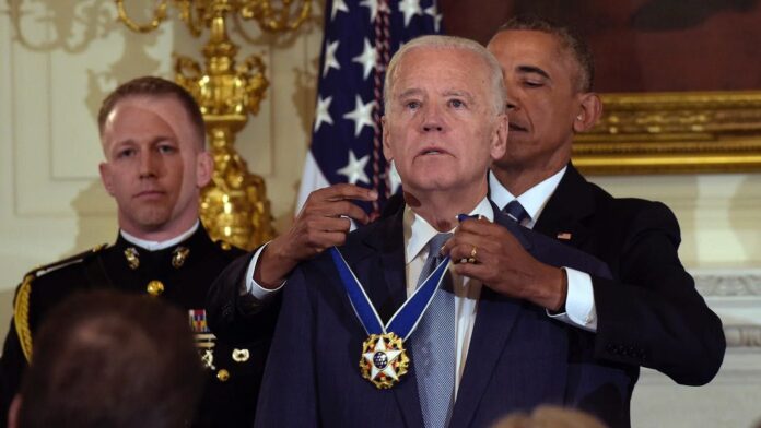 President Barack Obama presents Vice President Joe Biden with the Presidential Medal of Freedom during a ceremony in the State Dining Room of the White House in Washington, Jan. 12, 2017. (AP Photo/Susan Walsh)