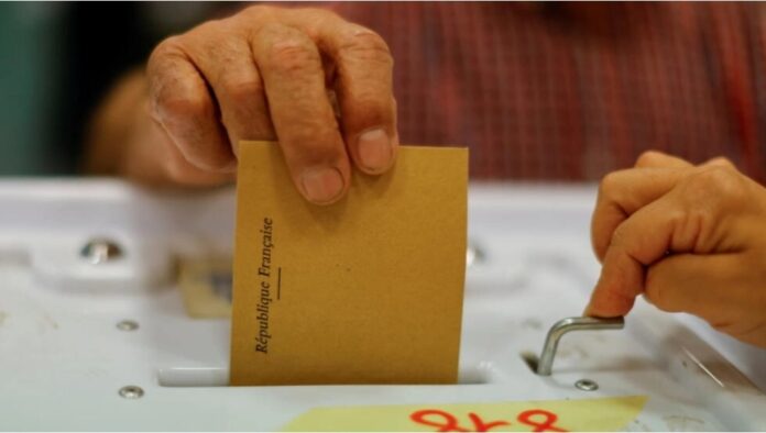 A voter casts his ballot in the first round of French parliamentary elections at a polling booth in Marseille, France, June 12, 2022. © Eric Gaillard, Reuters
