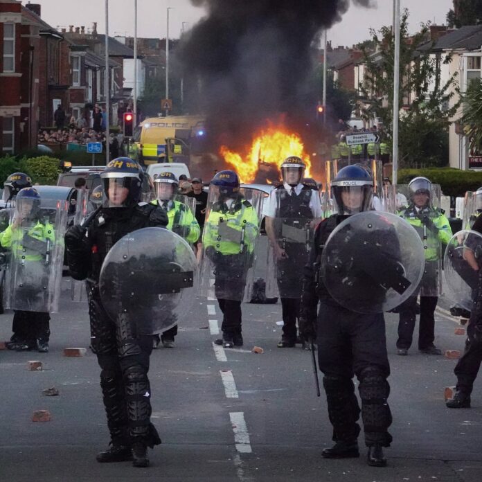 Riot police officers attempting to control violent unrest in Southport, England, on Tuesday, hours after a vigil for three girls killed in a stabbing attack.Credit...Getty Images/Getty Images