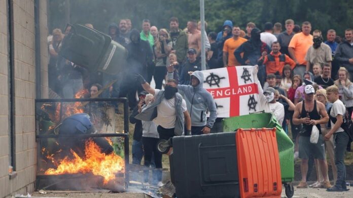 Demonstrators toss a trash bin during an anti-immigration protest, in Rotherham, Britain, August 4, 2024. (Reuters)