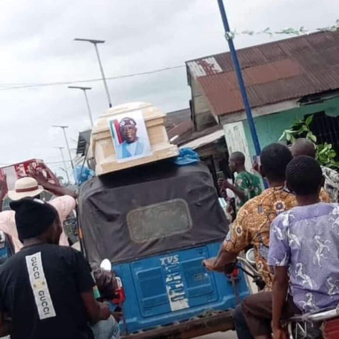 Nigerians Display 'Empty Coffin' With Tinubu's Poster In Similar Fashion Of 2012 Protests Under Jonathan