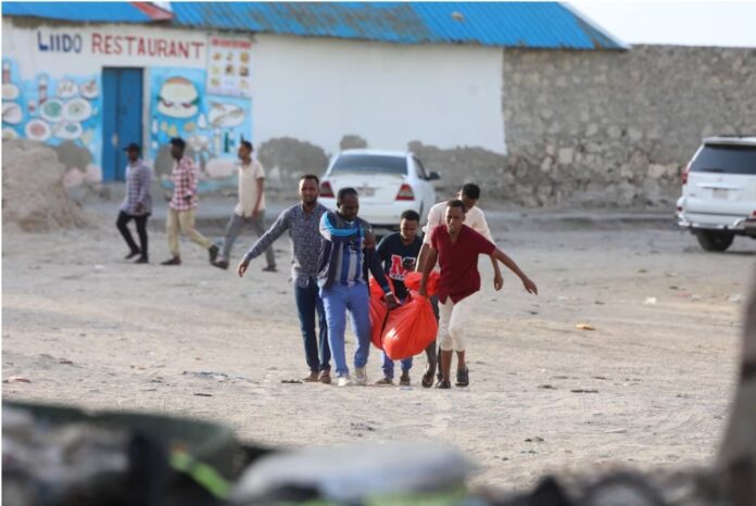 Relatives carry the body of a woman killed during the attack on Lido beach in Mogadishu on Friday. Photograph: Hassan Ali Elmi / AFP via Getty Images