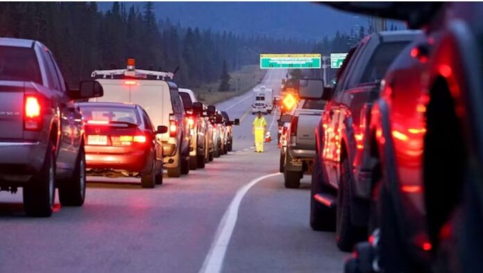Vehicles line the highway outside the east gates to Jasper National Park Friday as re-entry to the community began for thousands of residents forced out by wildfire last month. Photo: Radio-Canada / Emilio Avalos