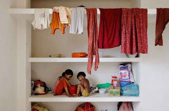 Children eat snacks while sitting on a concrete shelf as they shelter in a madrasa amid severe flooding, in the Fazilpur area of Feni, Bangladesh, August 26, 2024. REUTERS/Mohammad Ponir Hossain
