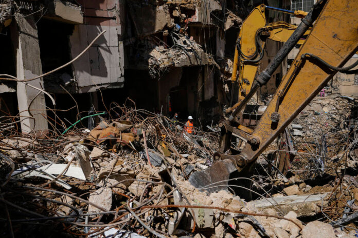 Rescuers sift through the rubble as they search for people still missing at the site of Friday’s Israeli strike in Beirut’s southern suburbs, Monday, Sept. 23, 2024. (AP Photo/Hassan Ammar)