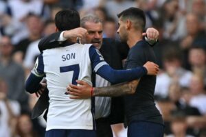 Tottenham’s Coach Ange Postecoglou (C) embraces striker Son Heung-Min (L) and defender #17 Cristian Romero (R) on the pitch after the English Premier League football match between Tottenham Hotspur and Brentford at the Tottenham Hotspur Stadium in London, on September 21, 2024. – Tottenham won the game 3-1. (Photo by Glyn KIRK / AFP)