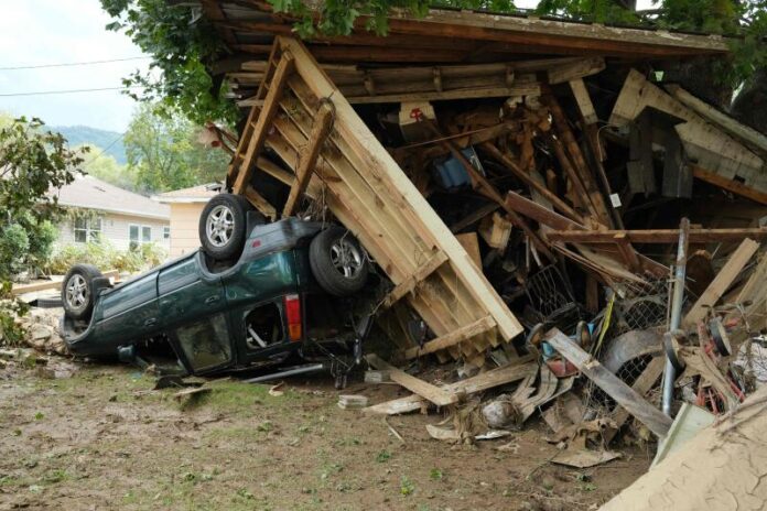 A damaged car sits under a destroyed shed after flooding caused by Hurricane Helene in Swannanoa, North Carolina, on October 3, 2024. ULYSSE BELLIER / AFP