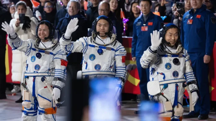 Astronauts (L-R) Wang Haoze, Song Lingdong and Cai Xuzhe wave before the launch