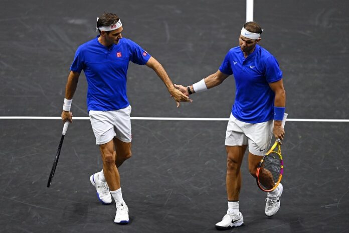 (FILES) In this file photo taken on September 23, 2022 Switzerland’s Roger Federer (L) gestures to Spain’s Rafael Nadal (R) of Team Europe playing against USA’s Jack Sock and USA’s Frances Tiafoe of Team World during their 2022 Laver Cup men’s doubles tennis match at the O2 Arena in London on September 23, 2022. (Photo by Glyn KIRK / AFP)