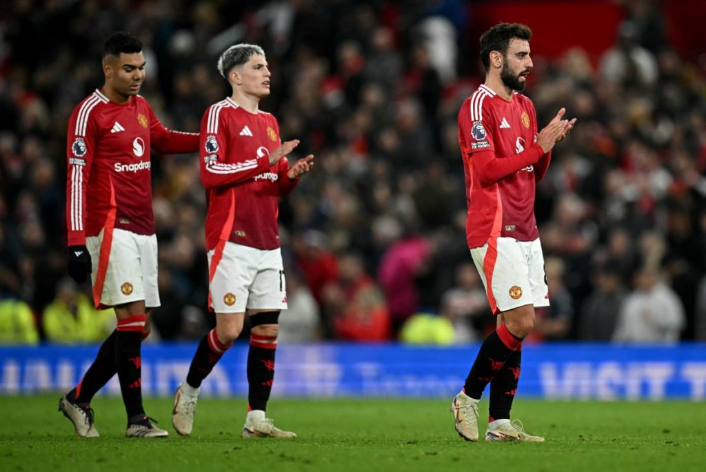 Chelsea’s Argentinian midfielder #08 Enzo Fernandez (R) Manchester United’s Argentinian midfielder #17 Alejandro Garnacho (C) and Manchester United’s Brazilian midfielder #18 Casemiro applauds the fans following the English Premier League football match between Manchester United and Chelsea at Old Trafford in Manchester, north west England, on November 3, 2024. (Photo by Paul ELLIS / AFP)